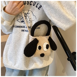 Detailed knit texture of handmade beige cartoon dog crochet bag worn on shoulder