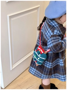 Detail of hand-knitted Christmas tree shoulder bag for kids with festive decorations