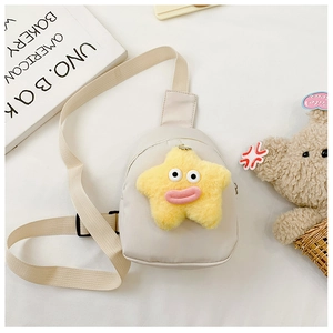 Dettaglio della borsa a tracolla crema per bambini con ciondolo a stella di peluche