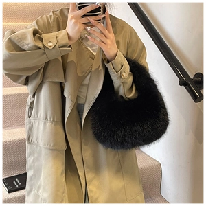 Détail d'un sac à main noir en fausse fourrure porté par un mannequin en trench-coat kaki