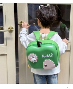 Dettaglio di bambino con zaino verde mela decorato con una simpatica applicazione a coniglio