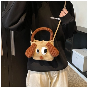 Detail view of handmade crochet puppy bag showing knit texture and 3D ears on a kid's shoulder