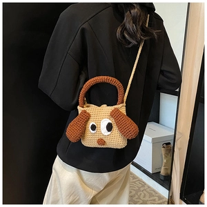 Detail showing handcrafted crochet puppy bag with large eyes and thick knit texture