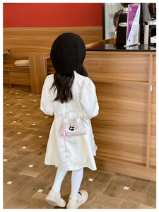 Pink girl's bag with panda embroidery and pearl handle worn by a child model