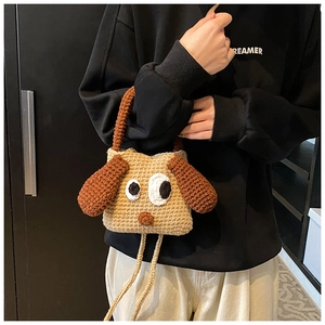 Detail of a handmade crochet dog-shaped child bag with long ears and woven texture