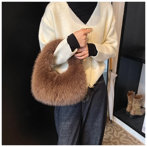 Gros plan sur le sac à main en fausse fourrure marron porté avec tenue d'automne