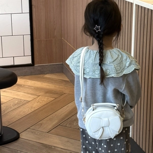White round children crossbody bag with bow decoration and adjustable shoulder strap