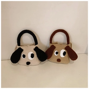 Detail of handmade crochet puppy shoulder bags in beige and khaki with big eyes