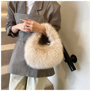 Détail du sac à main en peluche crème montrant la texture douce et la forme incurvée