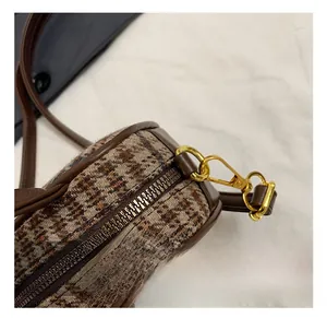 Detail of golden zipper and hardware on brown plaid bowling bag with high-quality metal finish