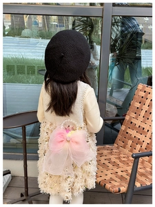 Detail of sweet girls' mini shoulder bag with large pink organza bow and pearl handle
