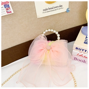 Close-up of pink bow and pearl handle on plush mini handbag for girls
