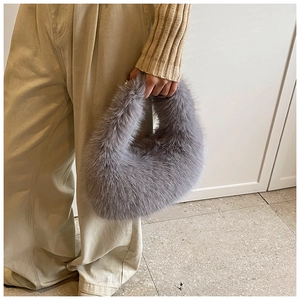 Gros plan sur un sac à main gris en fausse fourrure douce avec une forme de lune moderne
