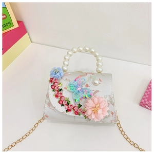 Detail of child handbag with 3D fabric flowers, pearl handle and gold chain strap