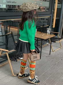 Detail of a green knit sweater and plaid bowling bag for kids autumn fashion outfit