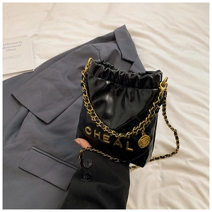 Detail der schwarzen gesteppten Beuteltasche mit Goldkette und Rosenanhänger-Zubehör