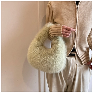 Gros plan sur un sac à main en fausse fourrure vert clair montrant sa texture douce
