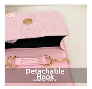 Gros plan sur le crochet doré amovible et la dentelle rose d'un sac pour enfant