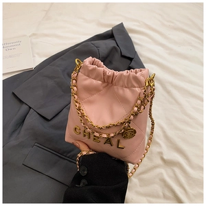 Detailansicht der rosa gesteppten Beuteltasche mit Goldkette und Kamelien-Anhänger