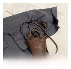 Brown lychee leather mini crossbody bag featuring golden Fashion & Bags text and top handles