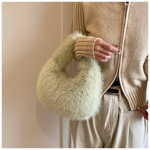 Détail du sac à main vert clair en fausse fourrure avec texture peluche et forme lune