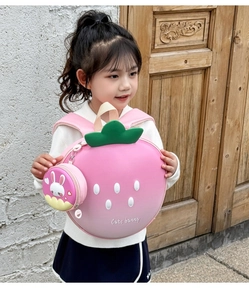 Outdoor view of a girl wearing the 3D strawberry backpack with cute bunny coin pouch