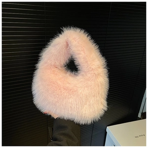 Détail de la fourrure synthétique rose clair douce d'un sac à main pelucheux