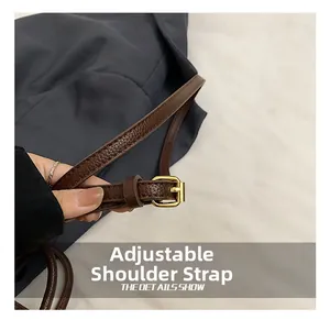 Close-up of adjustable leather shoulder strap with a gold buckle on the fabric bag