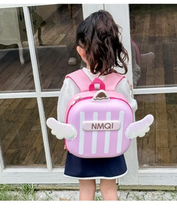 Detailed view of pink toddler backpack featuring white 3D wings and striped hardshell