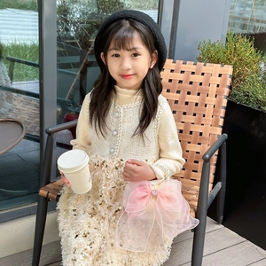 Cute girl's bow dress with pearls and matching shoulder bag in outdoor setting