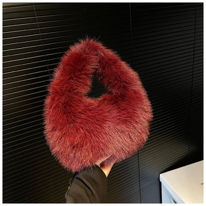 Gros plan du sac à main en peluche rouge vin montrant la texture douce de la fourrure