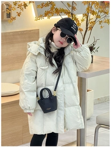Detail of off-white padded winter coat with a mini black crossbody bag for girls