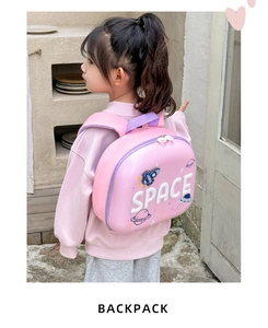 Close-up of pink hardshell toddler backpack with space rockets and planetary patterns