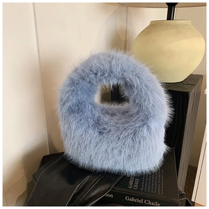 Gros plan d'un sac à main bleu clair en peluche avec fausse fourrure et poignée intégrée