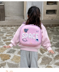Pink hardshell rocket backpack for kids with 3D Space theme shown on a child outdoors