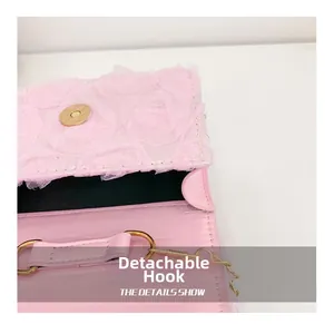 Detail of pink pearl handbag featuring a detachable golden hook and mesh rose texture
