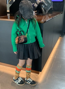 Kids leopard print mini crossbody bag paired with green cardigan and pleated skirt