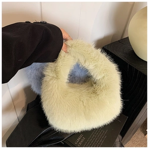 Détail du sac à main en peluche vert avec doublure bleue contrastante et texture