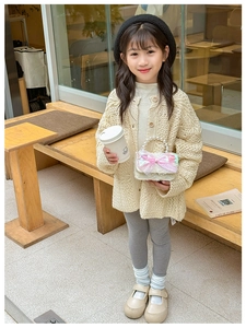 Cardigan beige en tricot pour fille et sac à main blanc à perles dans un café chic