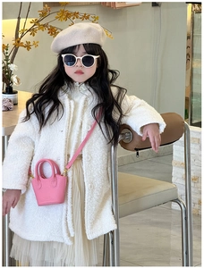 Pink mini leather handbag styled with a white plush coat on a young girl model