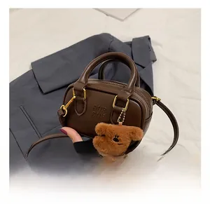 Braune Umhängetasche mit goldenem Reißverschluss und süßem Plüschbär-Anhänger Accessoire