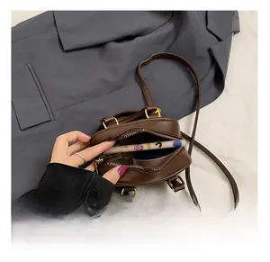 Detailansicht der Innenkapazität einer braunen Retro-Ledertasche mit Goldbeschlägen