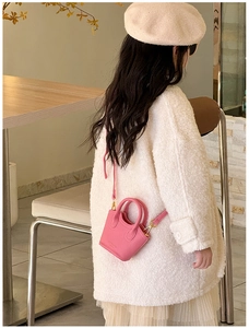 Detailed view of pink mini kids crossbody bag with lychee grain leather and gold hardware