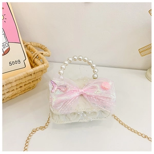 Détail du sac à main de princesse avec anse en perles et nœud en tulle rose
