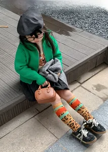 Outdoor-Aufnahme von stylischen Kniestrümpfen für Kinder mit Leopardenmuster und Streifen