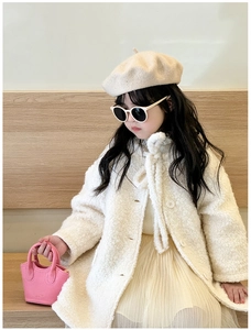 Toddler girl in faux fur coat and tutu skirt holding a pink mini basket bag in studio