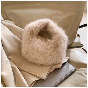 Détail d'un chapeau d'hiver en fausse fourrure beige clair posé sur une veste élégante