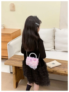 Pink mesh children crossbody bag featuring pearl handle and cute bow detail with metal chain