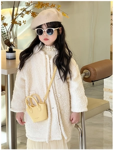 Detail of yellow mini basket bag paired with a white sherpa coat and beige beret