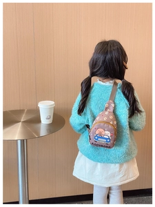 Kid's brown crossbody bag with Kapybara cartoon print shown on a child model